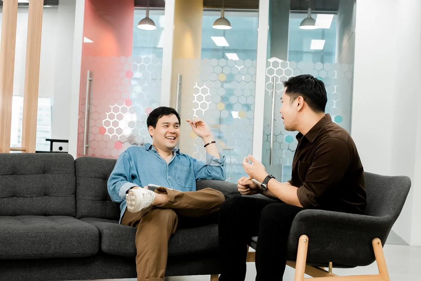 Two Primal colleagues laughing together on the office sofa